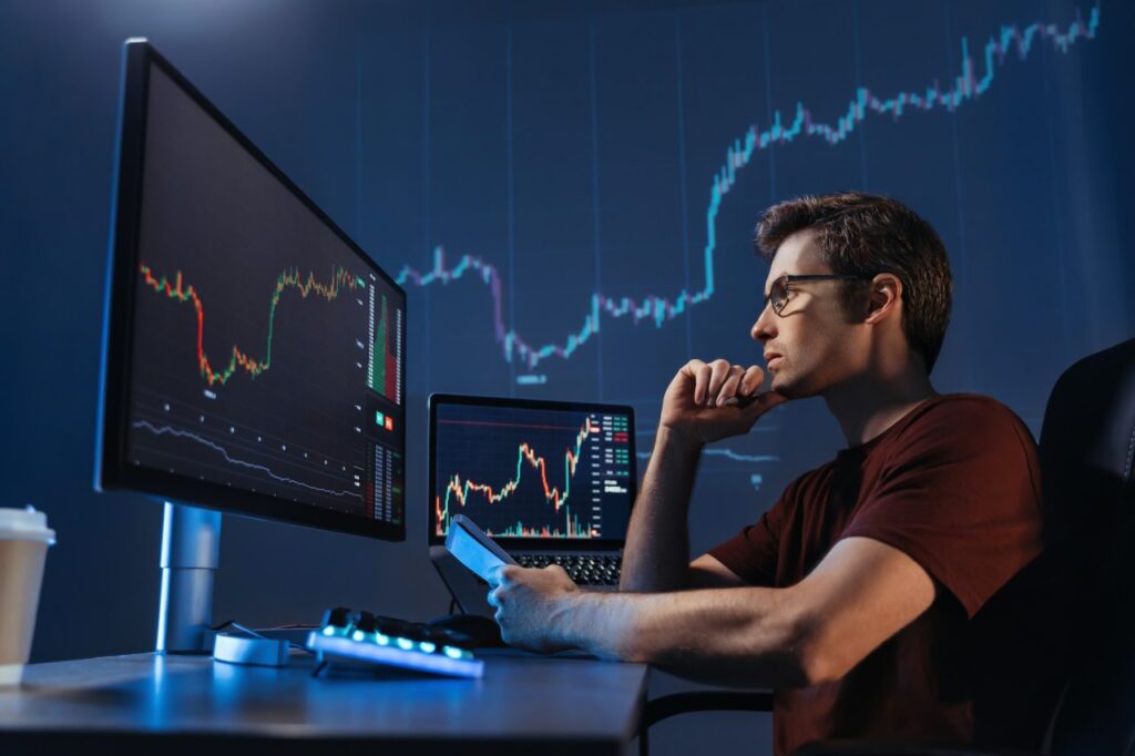 crypto-trader-sitting-in-front-of-computers-making-professional-analysis-of-candlestick-chart